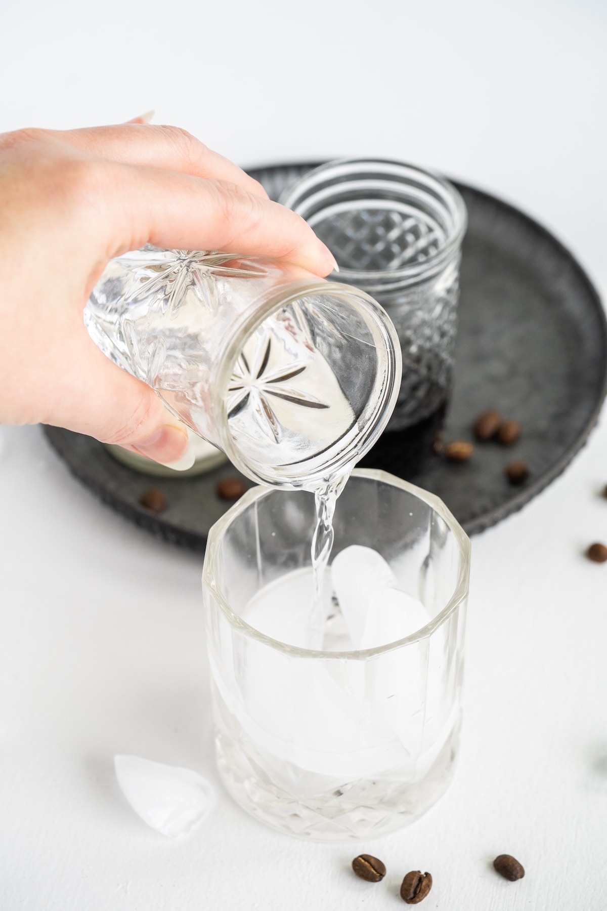 Vodka being poured into a cocktail glass to make a white russian
