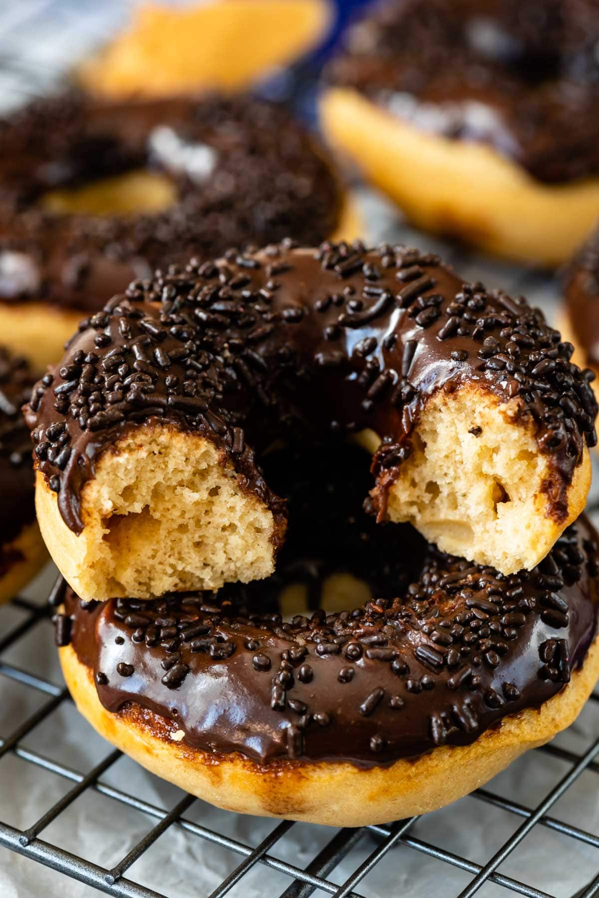 Close up shot of peanut butter baked donut stacked on another with one bite missing