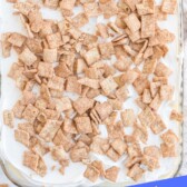 Overhead shot of cinnamon toast crunch poke cake with recipe title on bottom of photo