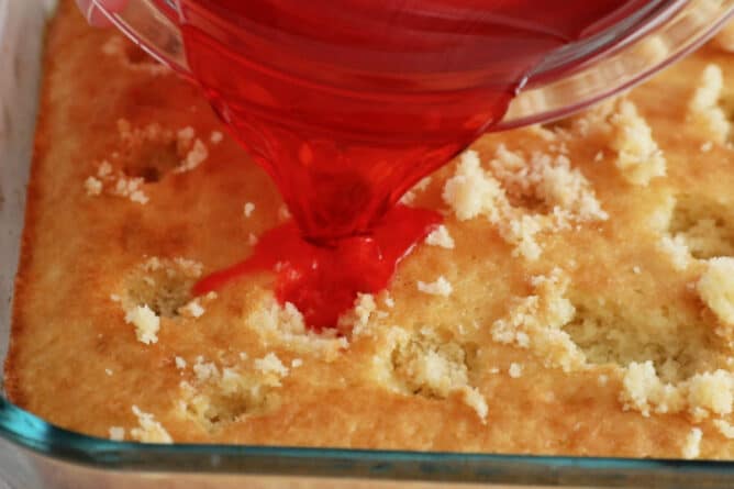 cake in pan with holes in it and jello being poured on