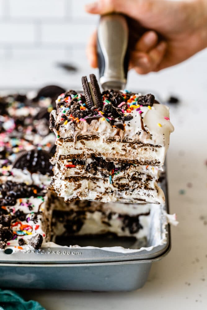 One piece of ice cream sandwich cake being scooped out of pan