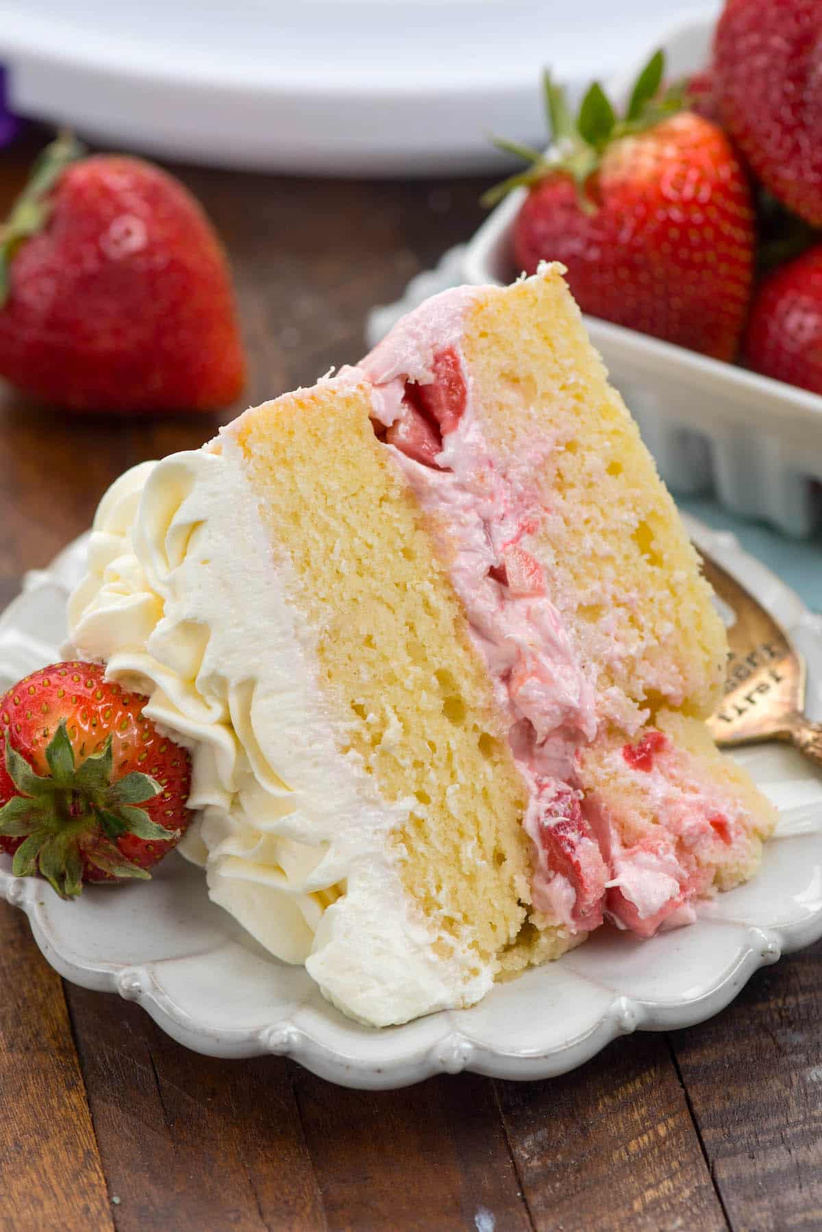 slice of cake laying on white plate on brown table