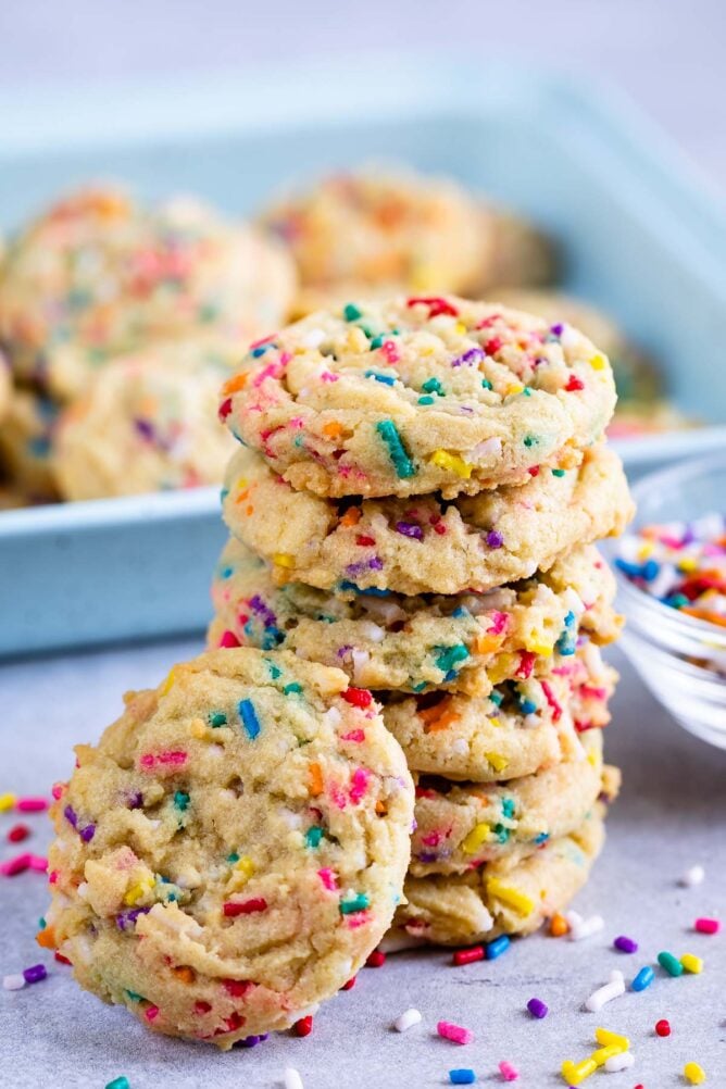 Tall stack of cake batter cookies with sprinkles around them