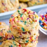 Tall stack of cake batter cookies with sprinkles around them