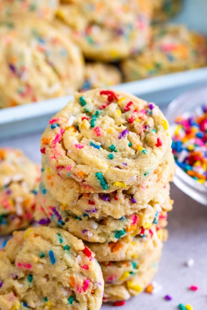 Tall stack of cake batter cookies with sprinkles around them