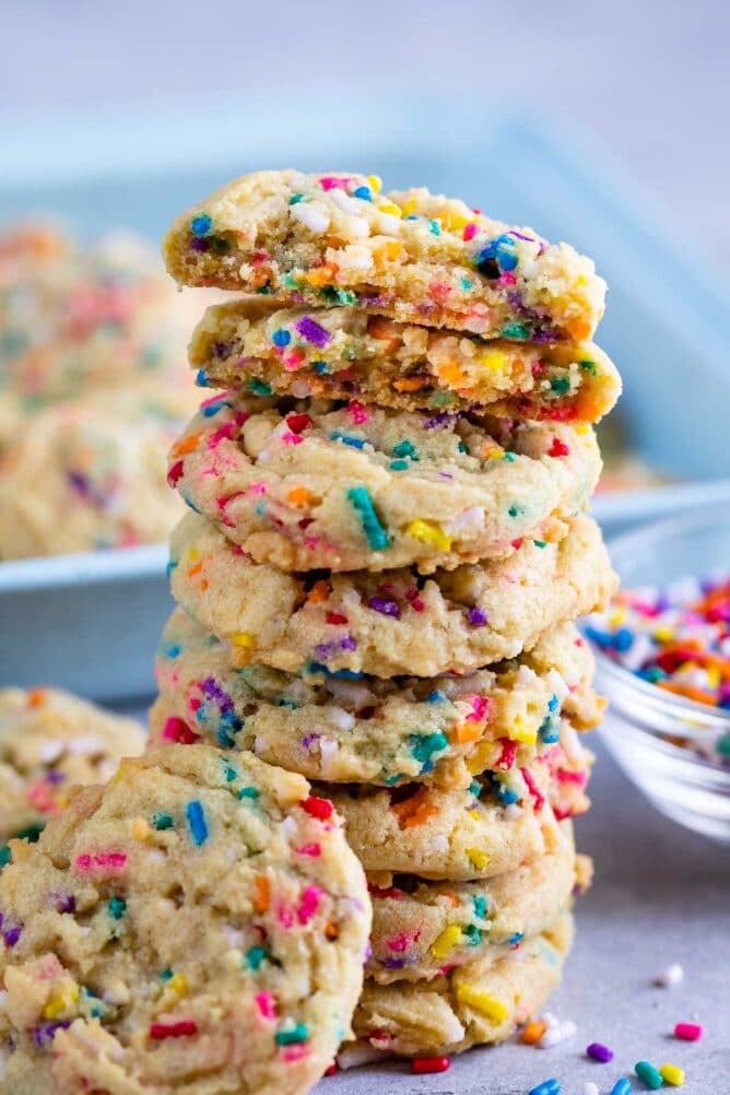 Tall stack of cake batter cookies with sprinkles around them