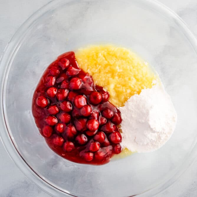 Overhead shot of mixing bowl with pineapple, cherries and pudding mix