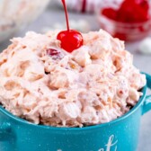 Turquoise mug filled with cherry fluff with a cherry on top