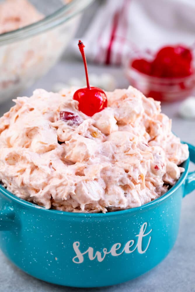 Turquoise mug filled with cherry fluff with a cherry on top