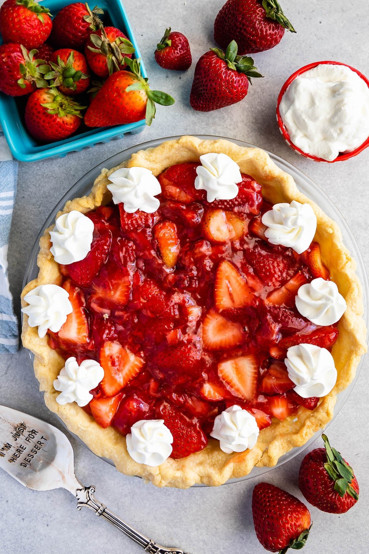 overhead shot of pie with whipped cream and berries around.