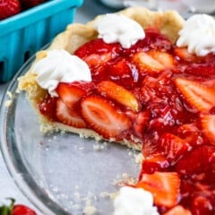 sliced pie in clear pie plate with whipped cream.