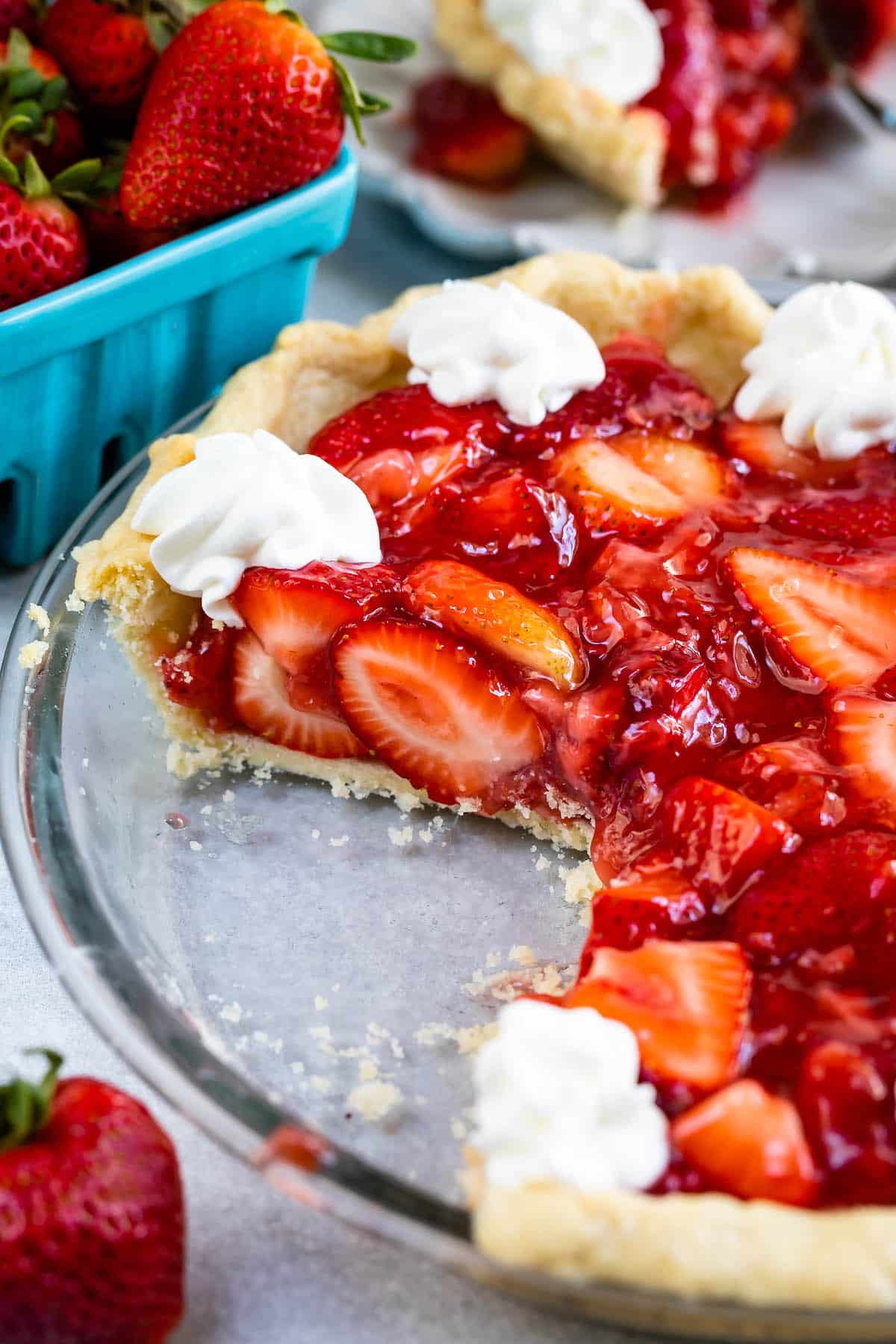 sliced pie in clear pie plate with whipped cream.