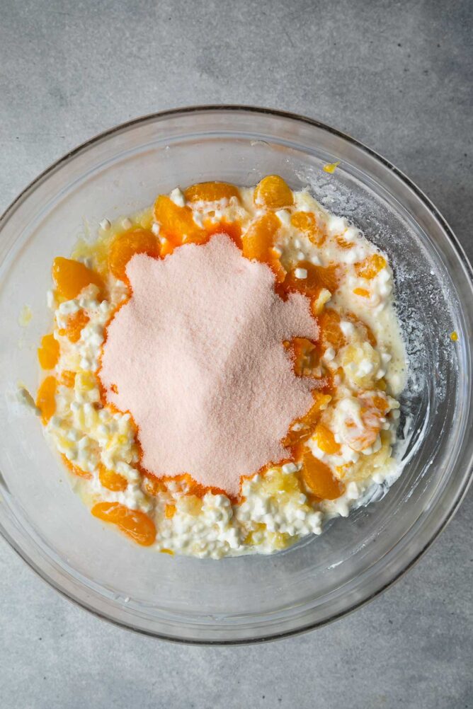Overhead shot of bowl filled with cottage cheese, mandarin oranges, crushed pineapple and orange jello