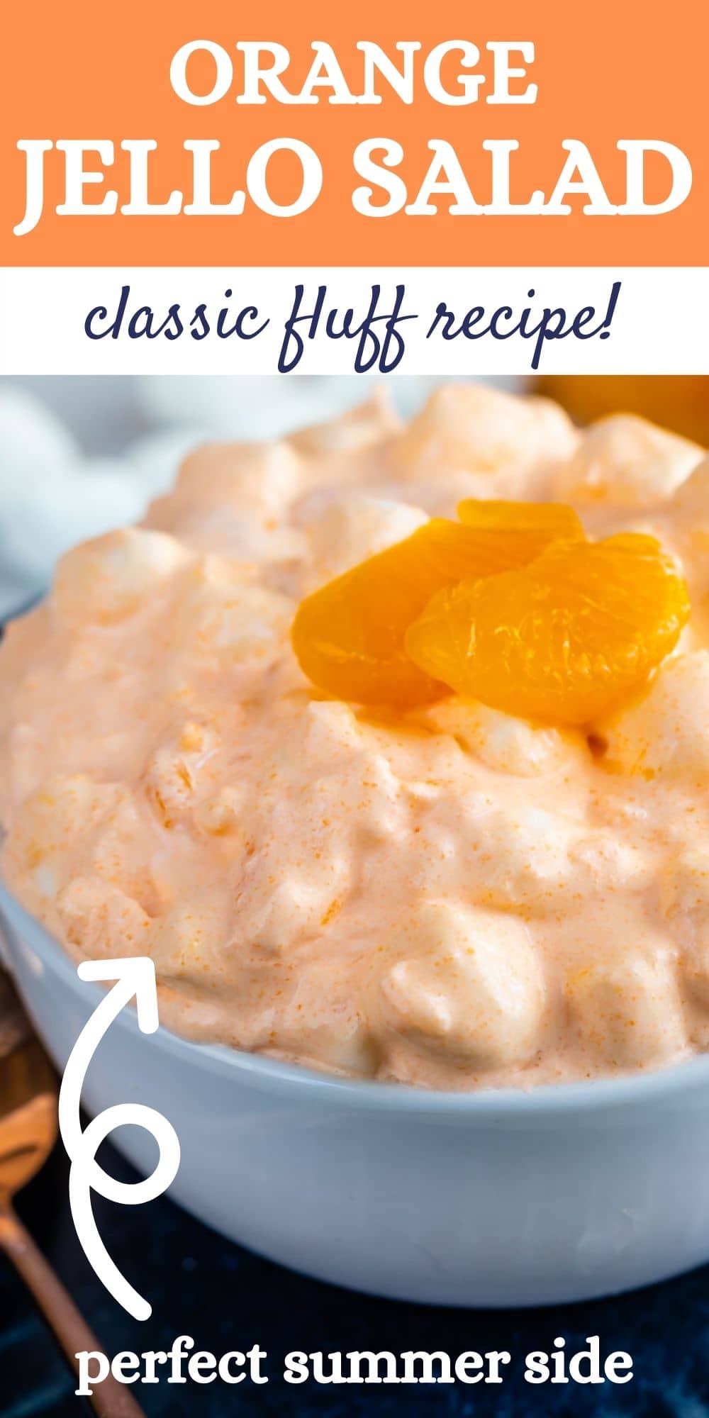 Orange jello salad in a small white bowl topped with mandarin oranges with recipe title on top of image