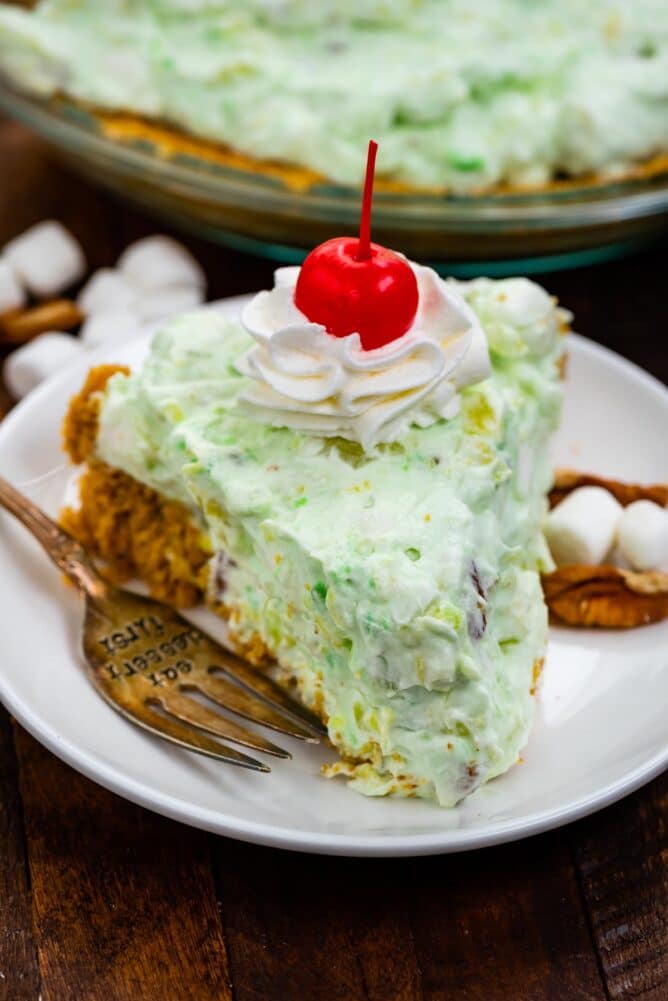 slice of pie filled with Watergate salad on white plate