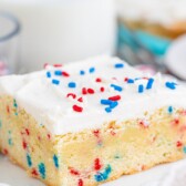 cookie bar with frosting and sprinkles on white plate
