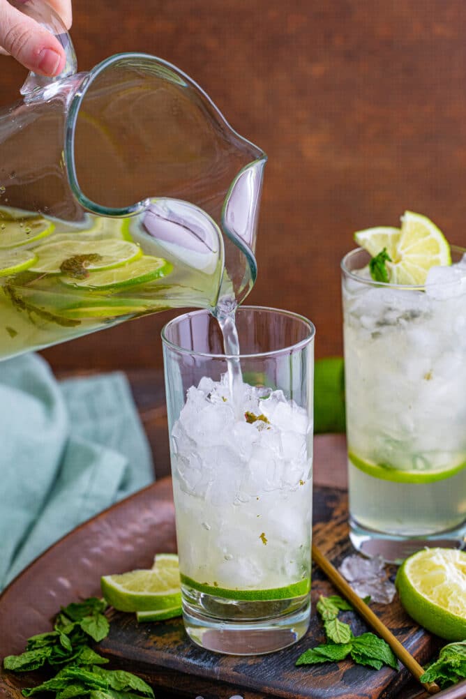 Pitcher mojito being poured into a single glass