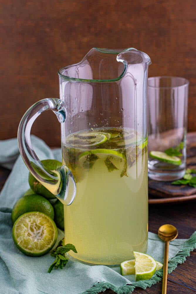 Pitcher of mojitos with ingredients around it