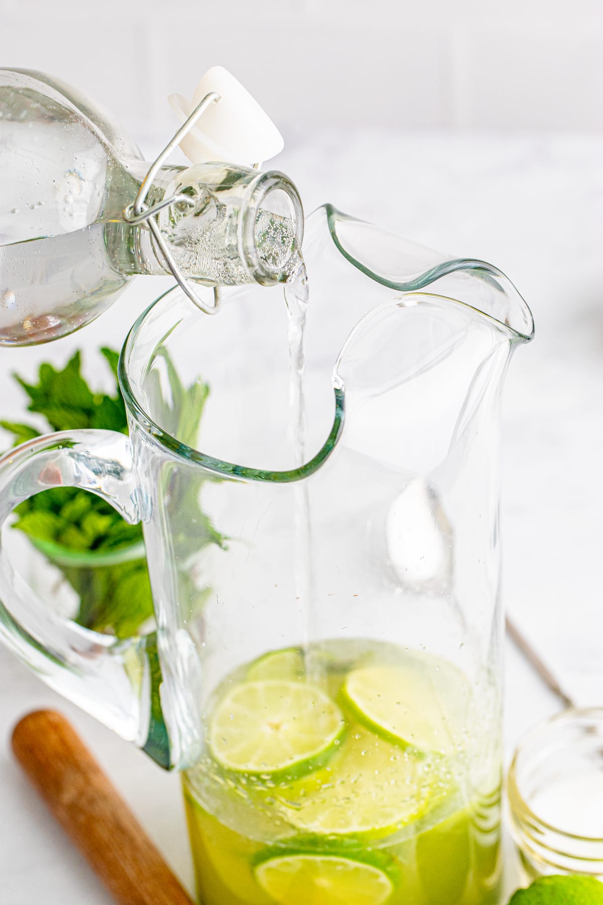 pitcher with hand pouring in liquid.