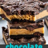 Stack of peanut butter stuffed chocolate cookie bars with the top bar missing one bite and recipe title on bottom of image