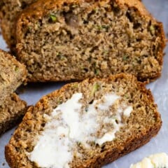 Slices of zucchini bread and front slice is lathered with butter