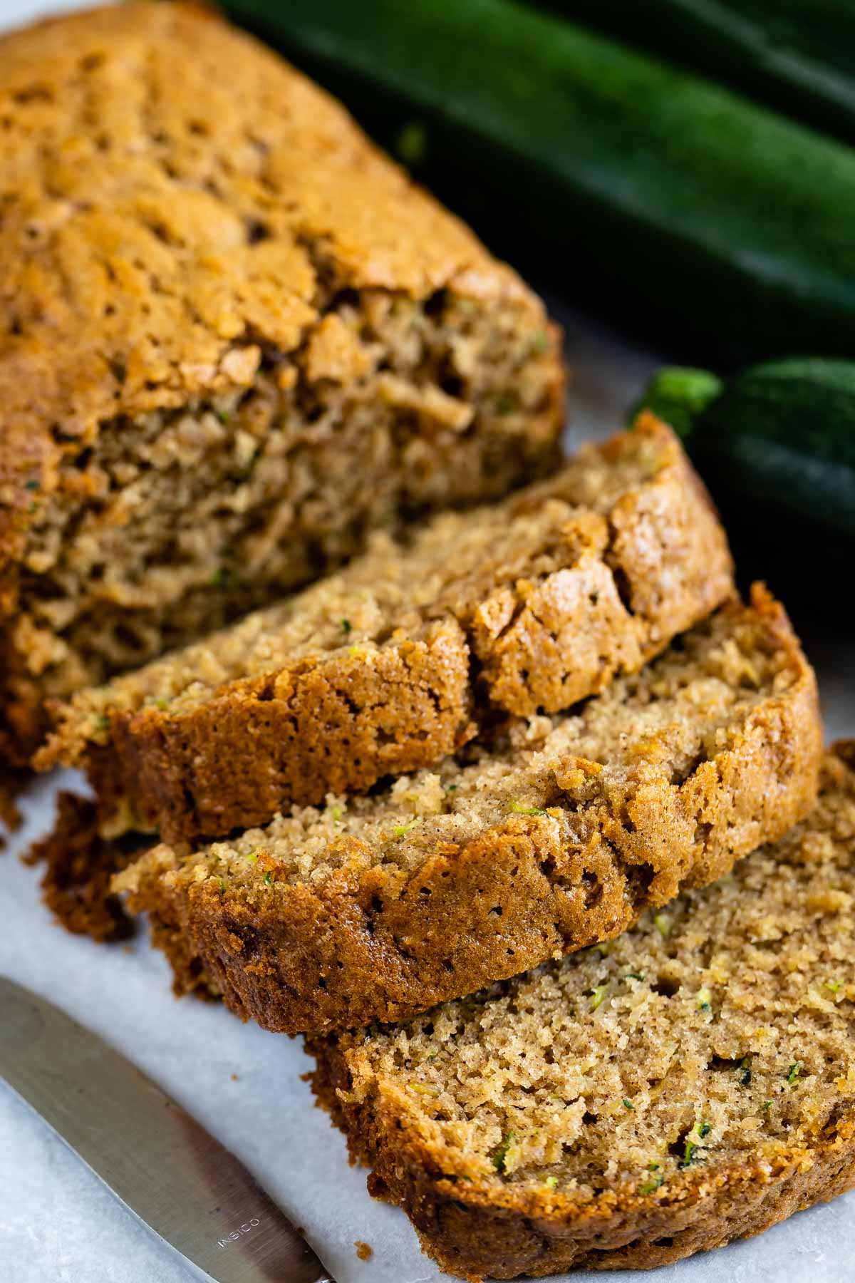 One loaf of zucchini bread with half cut into bread slices