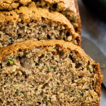 One loaf of zucchini bread with half cut into bread slices