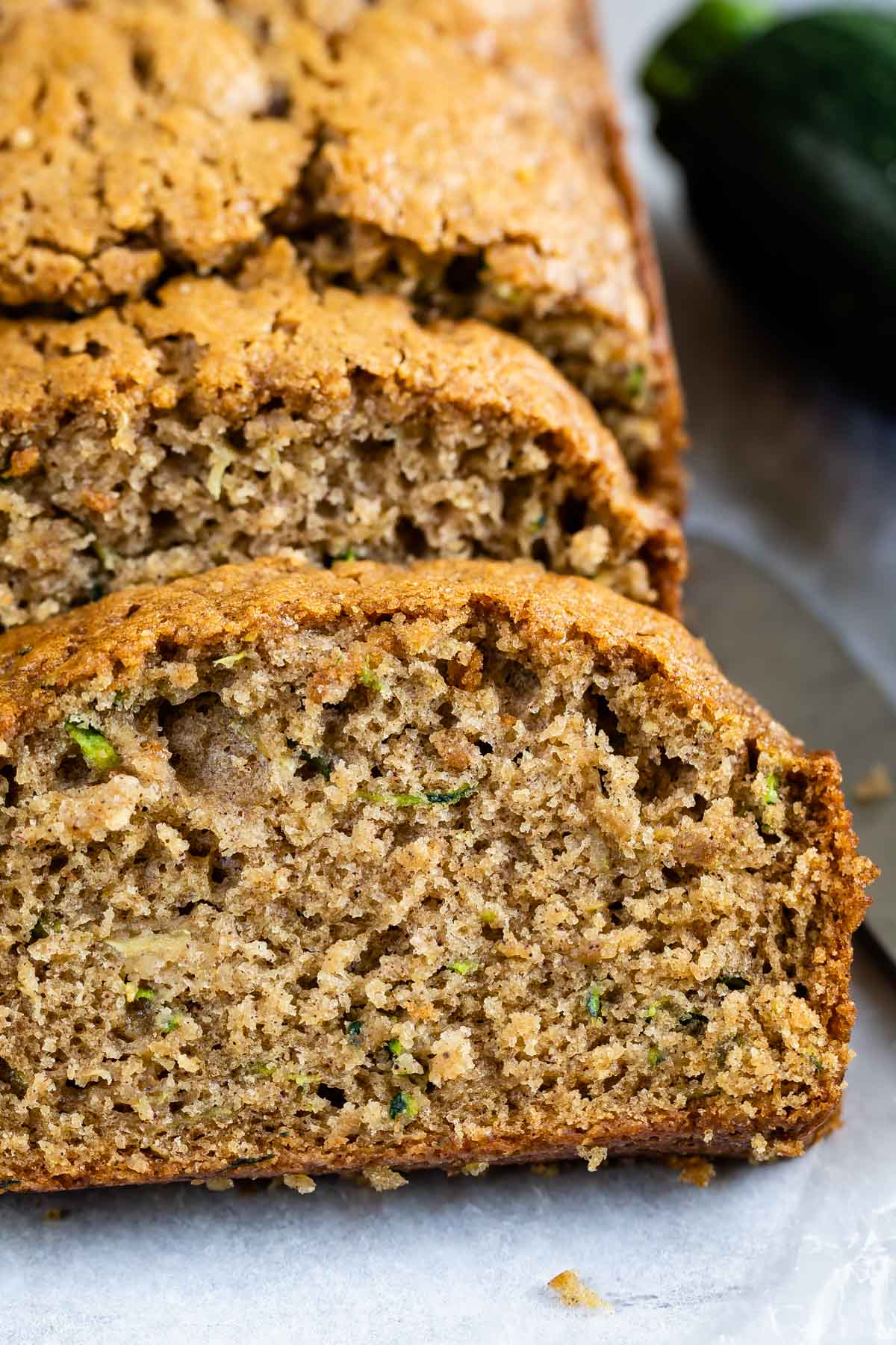 One loaf of zucchini bread with half cut into bread slices