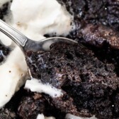 cake in mug with spoon and whipped cream