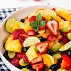 Big bowl of fruit salad on top of a checkered tablecloth