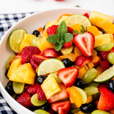 Big bowl of fruit salad on top of a checkered tablecloth