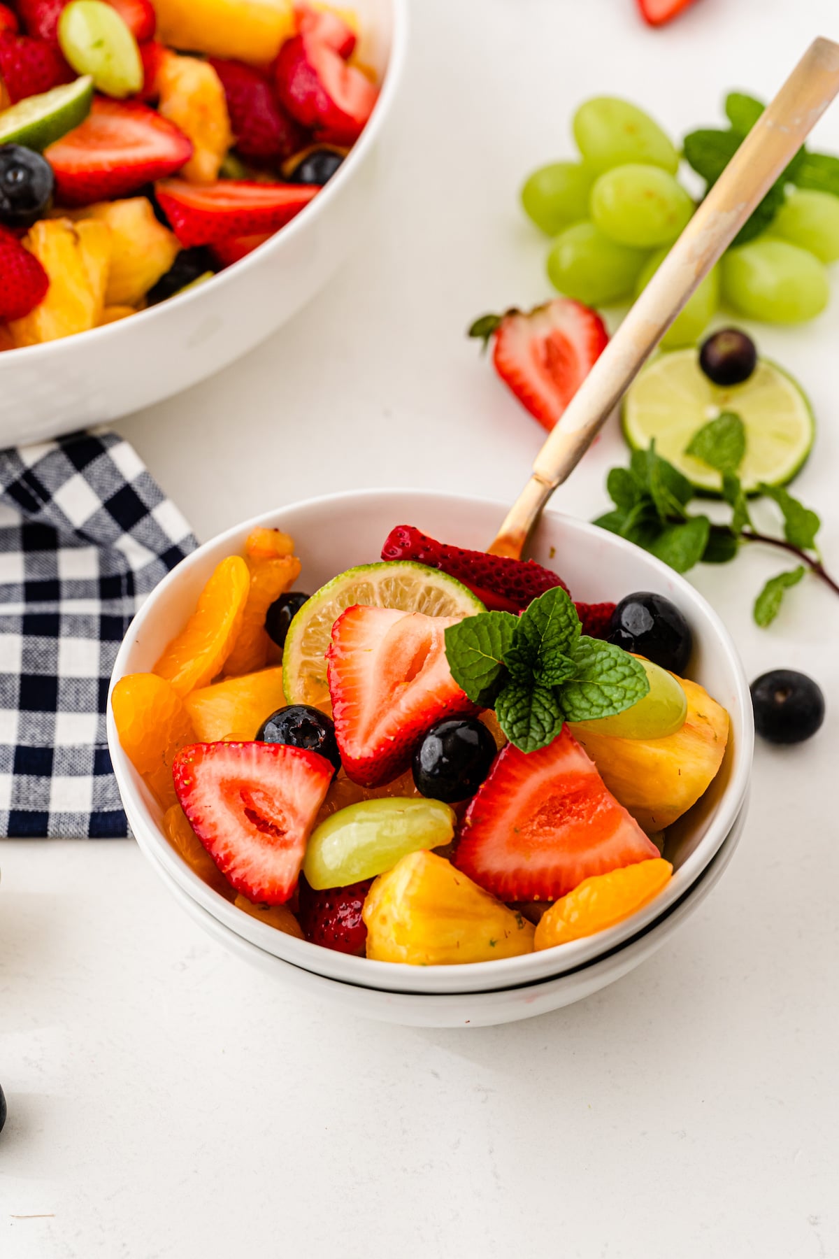 Small bowl of fruit salad with larger serving bowl in the background