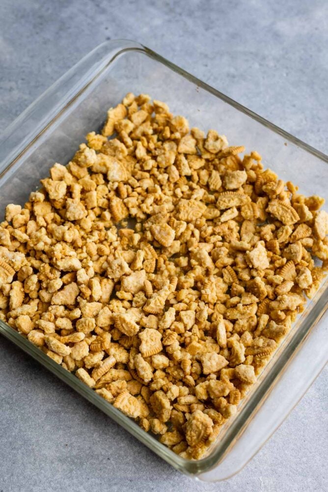 Crushed Golden Oreos in a square baking dish to be used as a crust