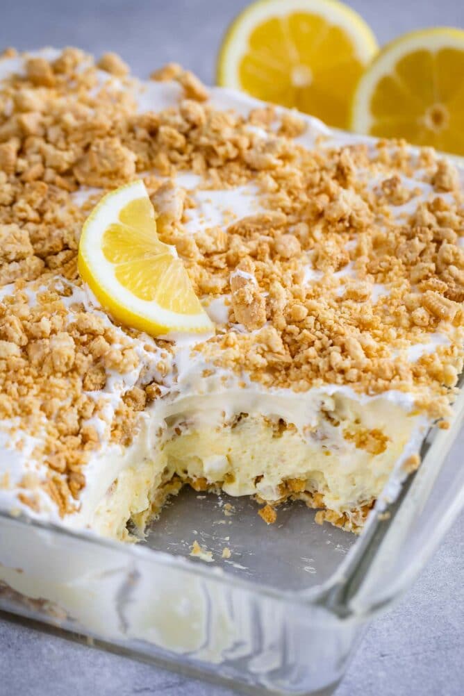 No bake lemon dessert in a glass baking dish with on corner piece missing
