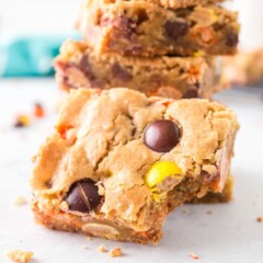 Stack of loaded cookie bars with one in front missing on bite