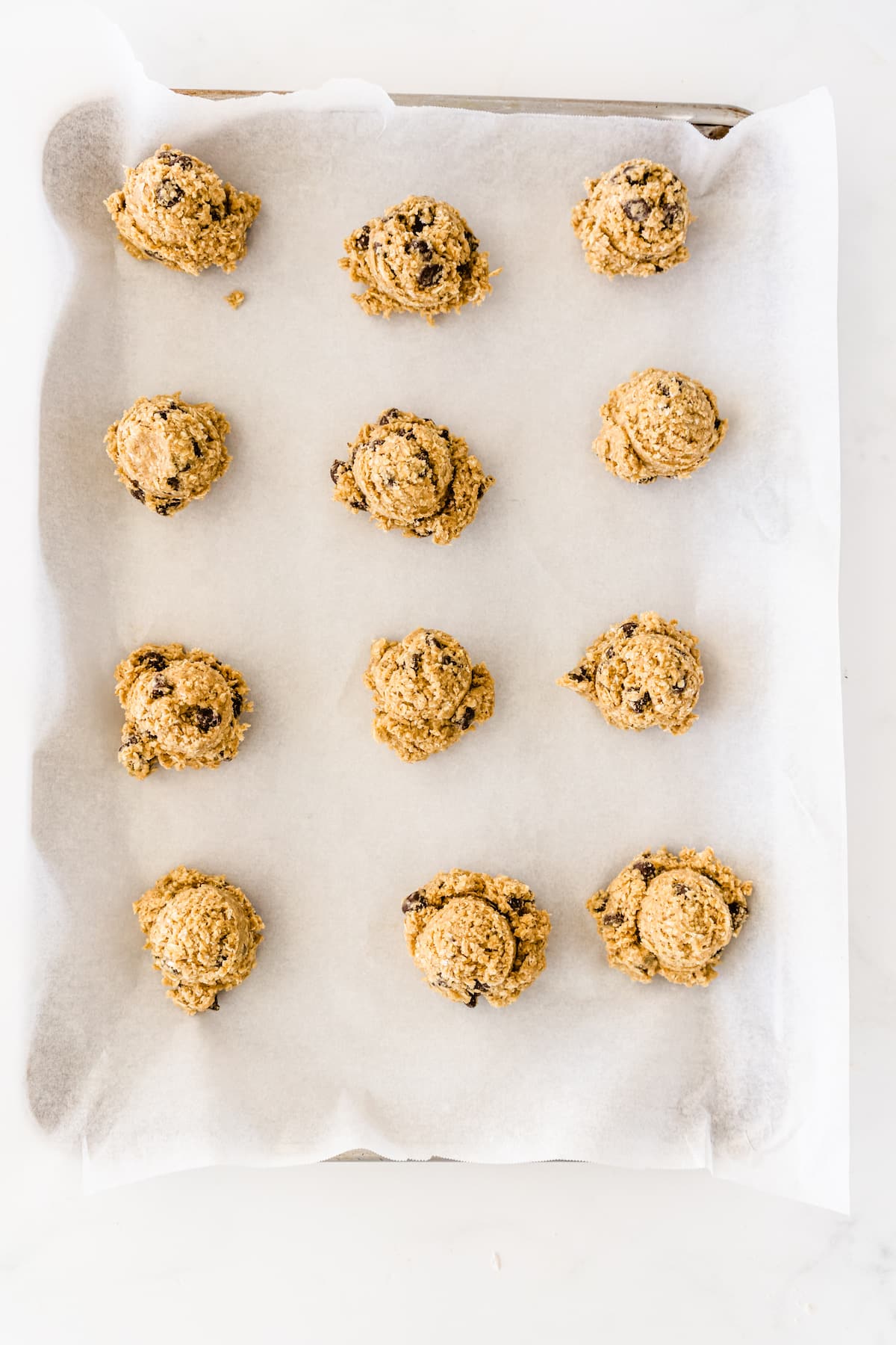 cookie sheet with 12 cookie dough balls on it.