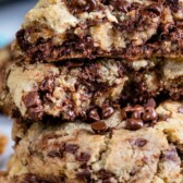Stack of bakery style chocolate chip cookies with recipe title on top of image