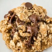 One oatmeal chocolate chip cookie with recipe title on top of image