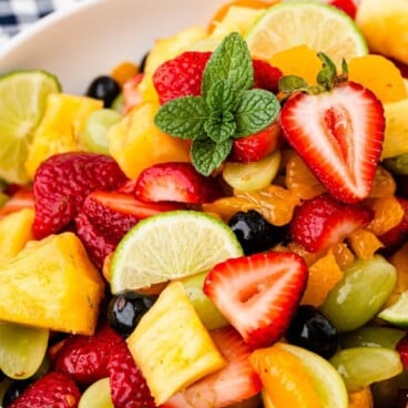 Bowl of fruit salad with recipe title on top of image