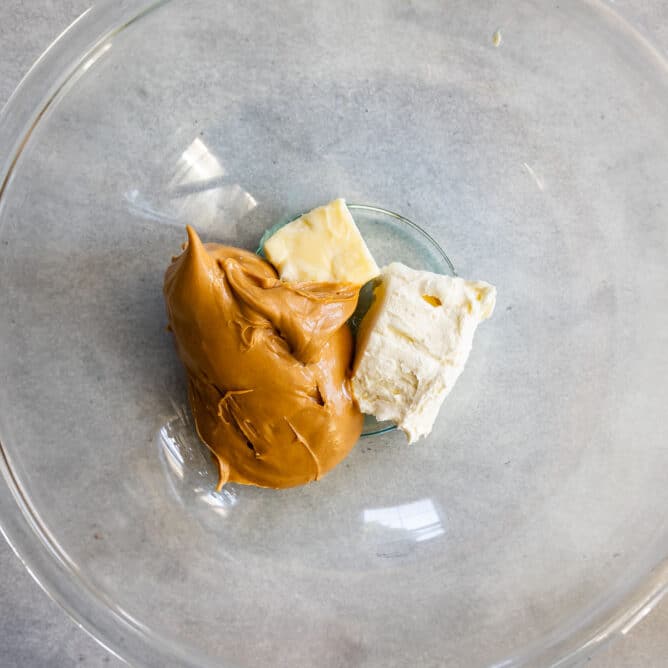 Overhead shot of peanut butter, butter and cream cheese in mixing bowl