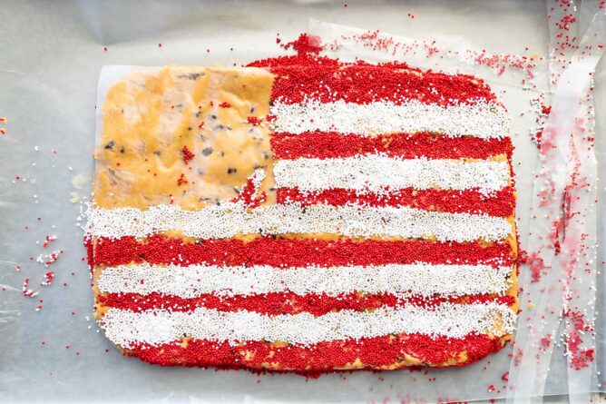 Overhead shot of peanut butter flag dip with red and white sprinkle stripes completed