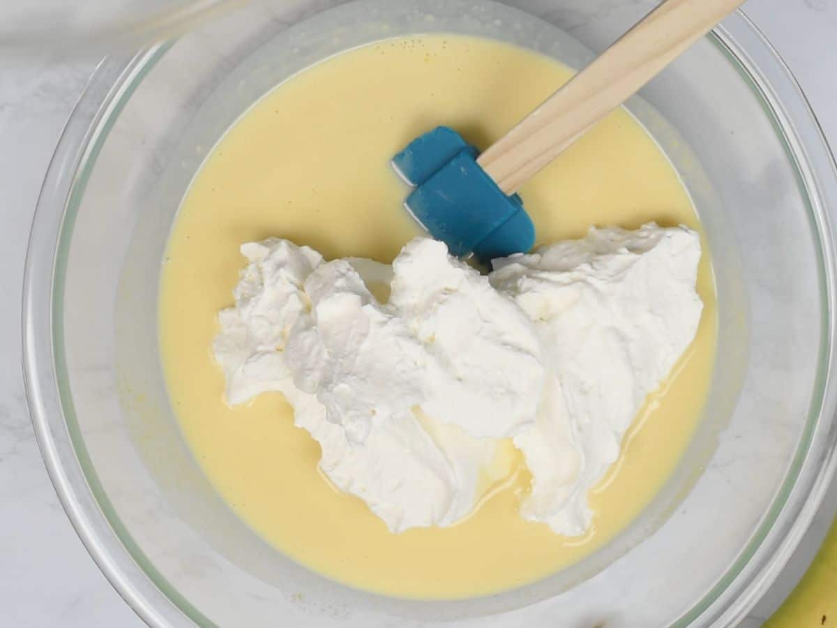 pudding in bowl with whipped cream.