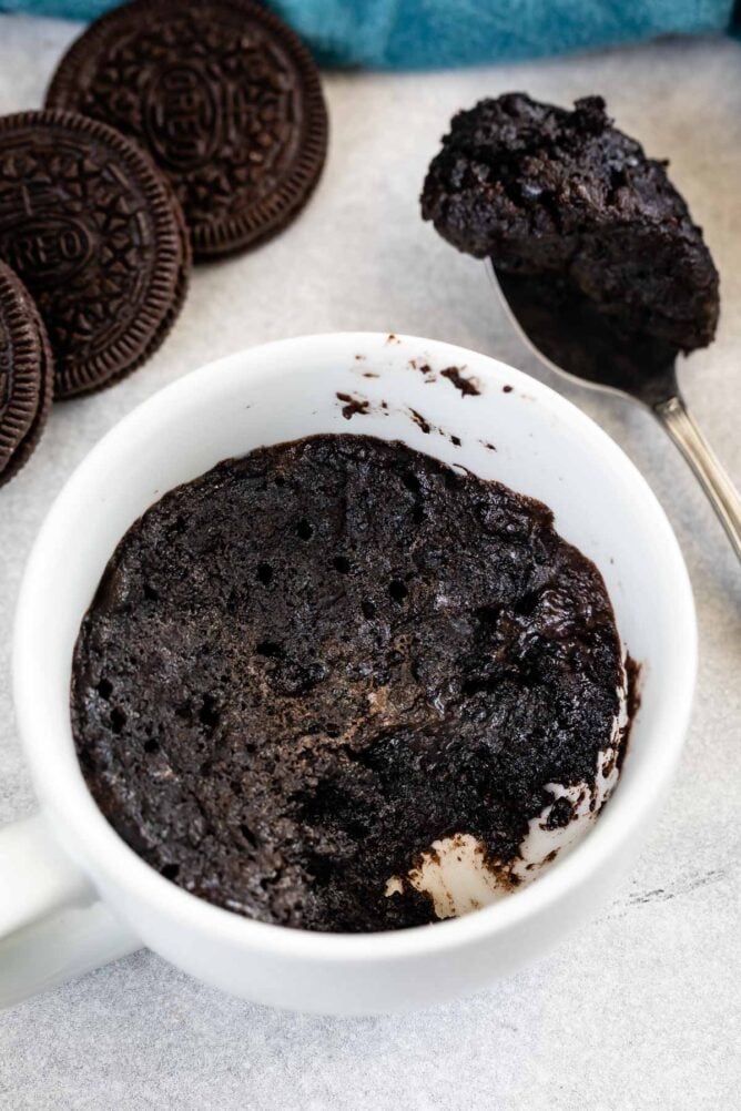 Overhead shot of Oreo mug cake with spoonful of cake next to it
