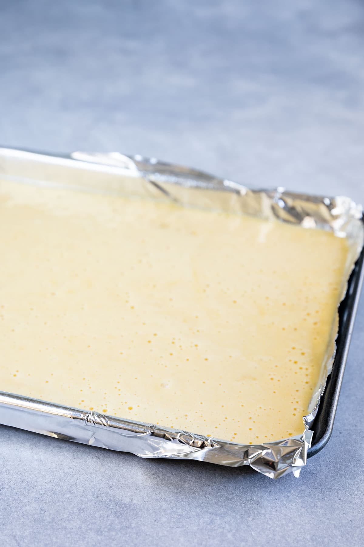 Vanilla cake batter in large sheet pan ready to be baked