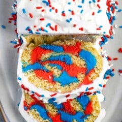 Overhead shot of patriotic cake roll with two pieces sliced into so you can see the inside