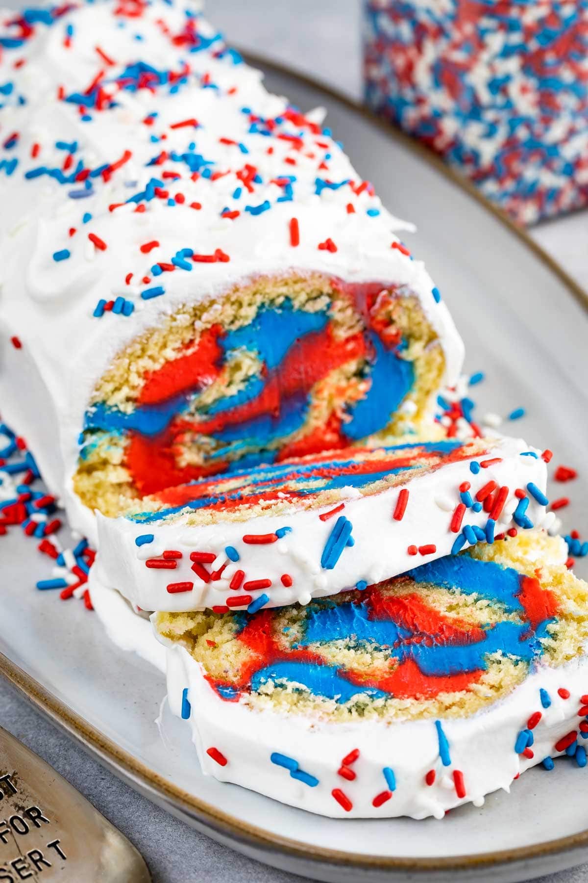 Side view of patriotic cake roll with two pieces cut into slices