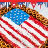 Overhead shot of peanut butter flag dip with pretzels around it and recipe title on top of image