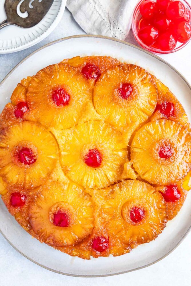 Overhead shot of pineapple upside down cake on a white rustic plate