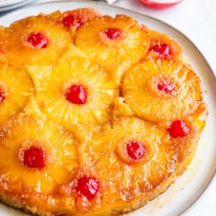 Overhead shot of pineapple upside down cake on a white rustic plate