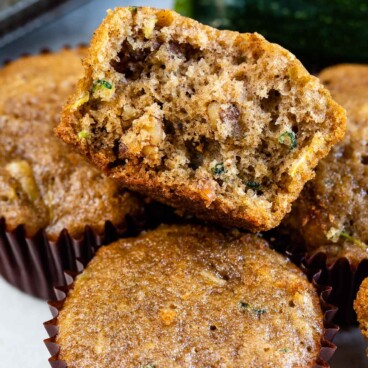 Zucchini muffins with top one split in half to show inside of muffin